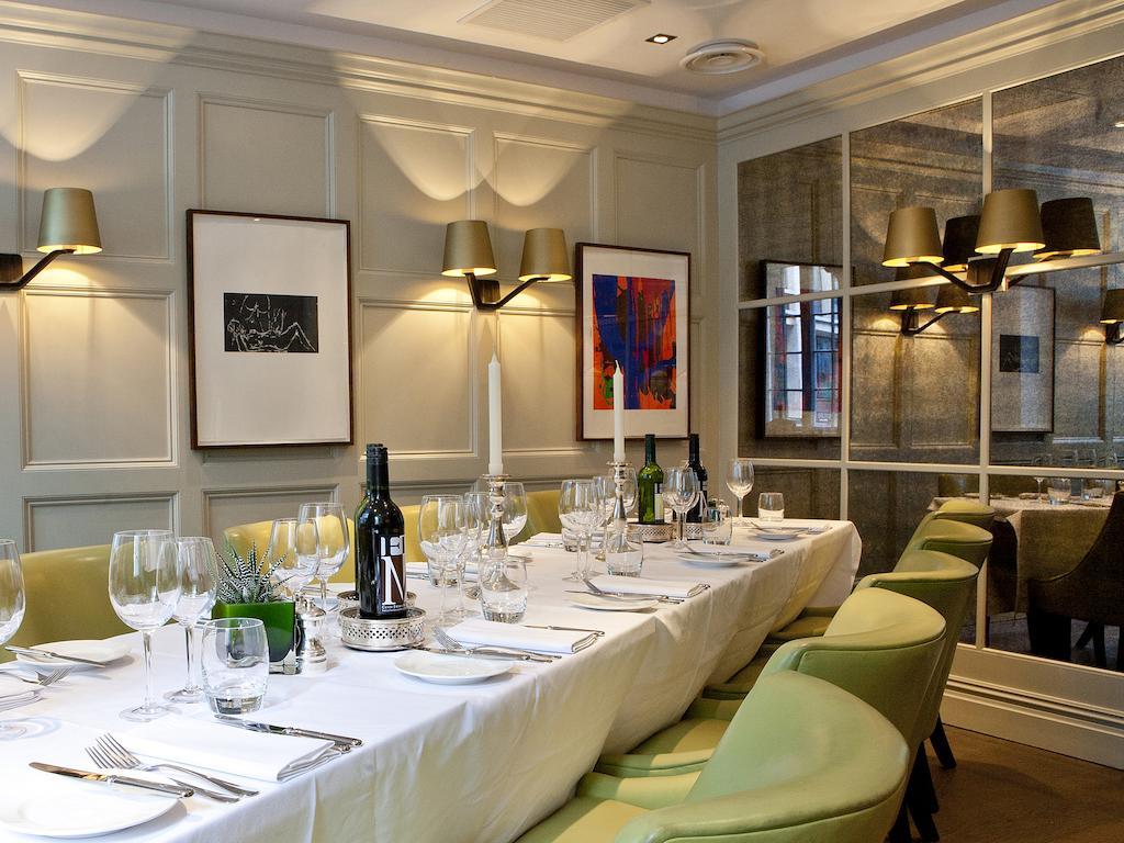 Hotel Montcalm Brewery Townhouse Londyn Zewnętrze zdjęcie The photo shows an elegant restaurant setting with a long dining table that is neatly set for a meal. The table is adorned with a white tablecloth, glassware, and silverware, indicating that it is prepared for a special gathering or event. 

Behind t