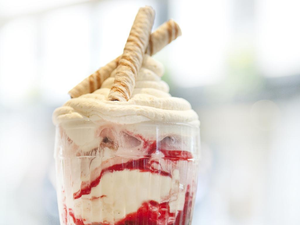 Hotel Montcalm Brewery Townhouse Londyn Zewnętrze zdjęcie The photo shows a delicious dessert in a clear glass dish. It features layers of creamy ice cream or whipped cream, swirled with a vibrant red fruit sauce. Topping the dessert are two rolled wafer sticks, adding a decorative touch. The overall presen