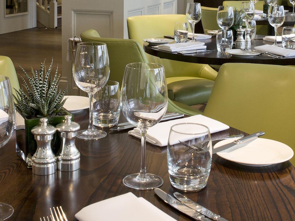 Hotel Montcalm Brewery Townhouse Londyn Zewnętrze zdjęcie The photo shows a dining setup in a restaurant. There are tables with a polished wooden surface and elegant place settings. Each setting includes multiple wine glasses and water glasses, neatly arranged with folded napkins. 

In the center, there are