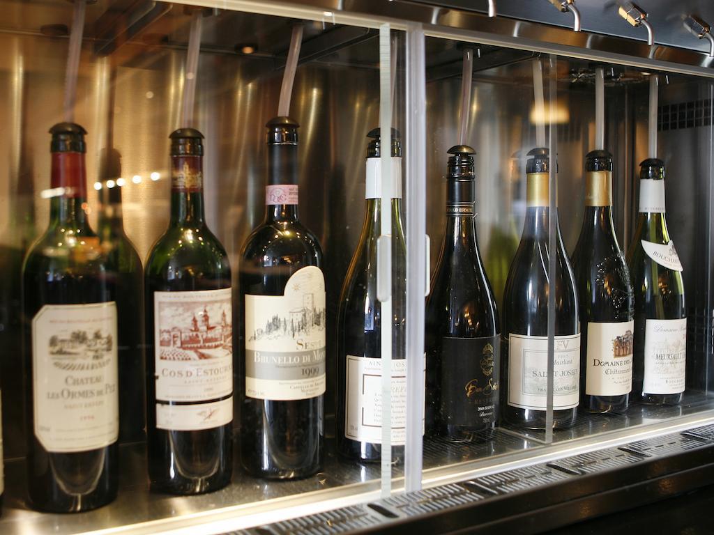 Hotel Montcalm Brewery Townhouse Londyn Zewnętrze zdjęcie The photo depicts a selection of wine bottles displayed in a wine fridge or cooler. The bottles are lined up behind a glass panel, showcasing various types of wine, likely including both red and white varieties. Each bottle has a distinctive label, i