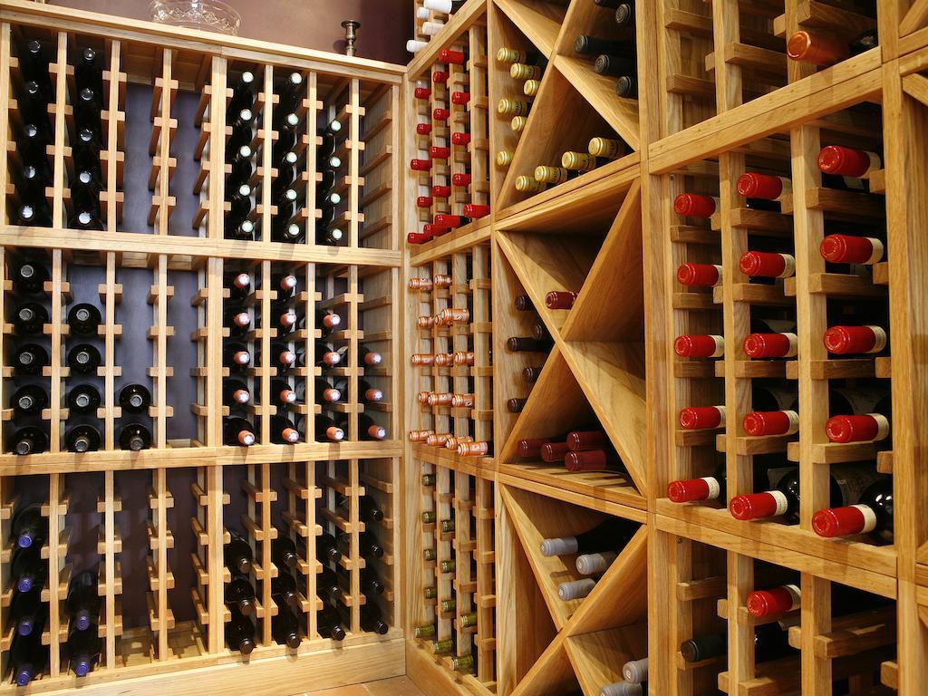 Hotel Montcalm Brewery Townhouse Londyn Zewnętrze zdjęcie The photo shows a wine cellar with wooden racks designed for storing wine bottles. The structure is divided into sections, featuring various compartments that hold the bottles in an organized manner. The bottles have different colors, with many red a